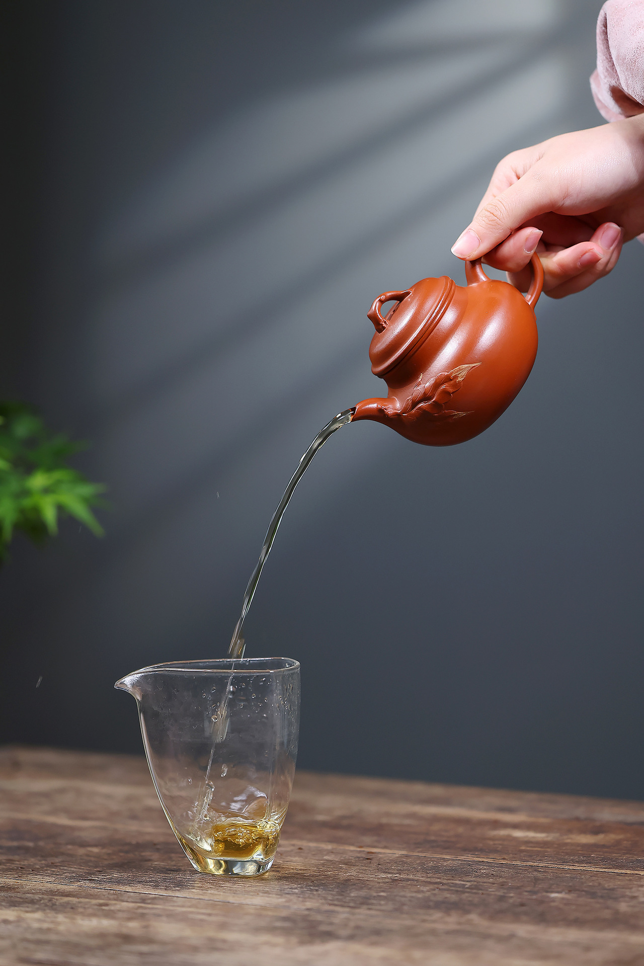 宜興紫砂壺原礦朱泥一葉知秋壺(220ml)，南山居紫砂壺手工沖泡普洱茶，茶水流暢注入玻璃公道杯，展現優雅茶道美學。