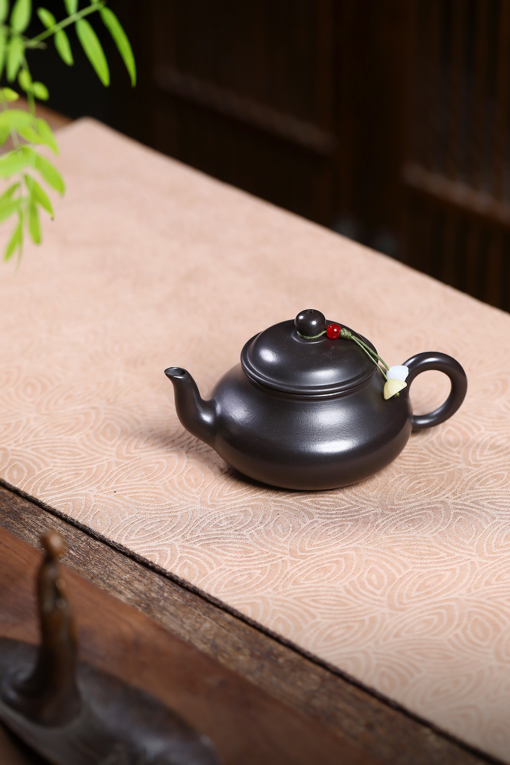 宜興紫砂壺原礦大紅袍捂灰梨形壺(150ml)，南山居精選黑泥紫砂壺，器型圓潤飽滿，壺蓋飾有精巧流蘇，展現手工茶具的雅緻與禪意。