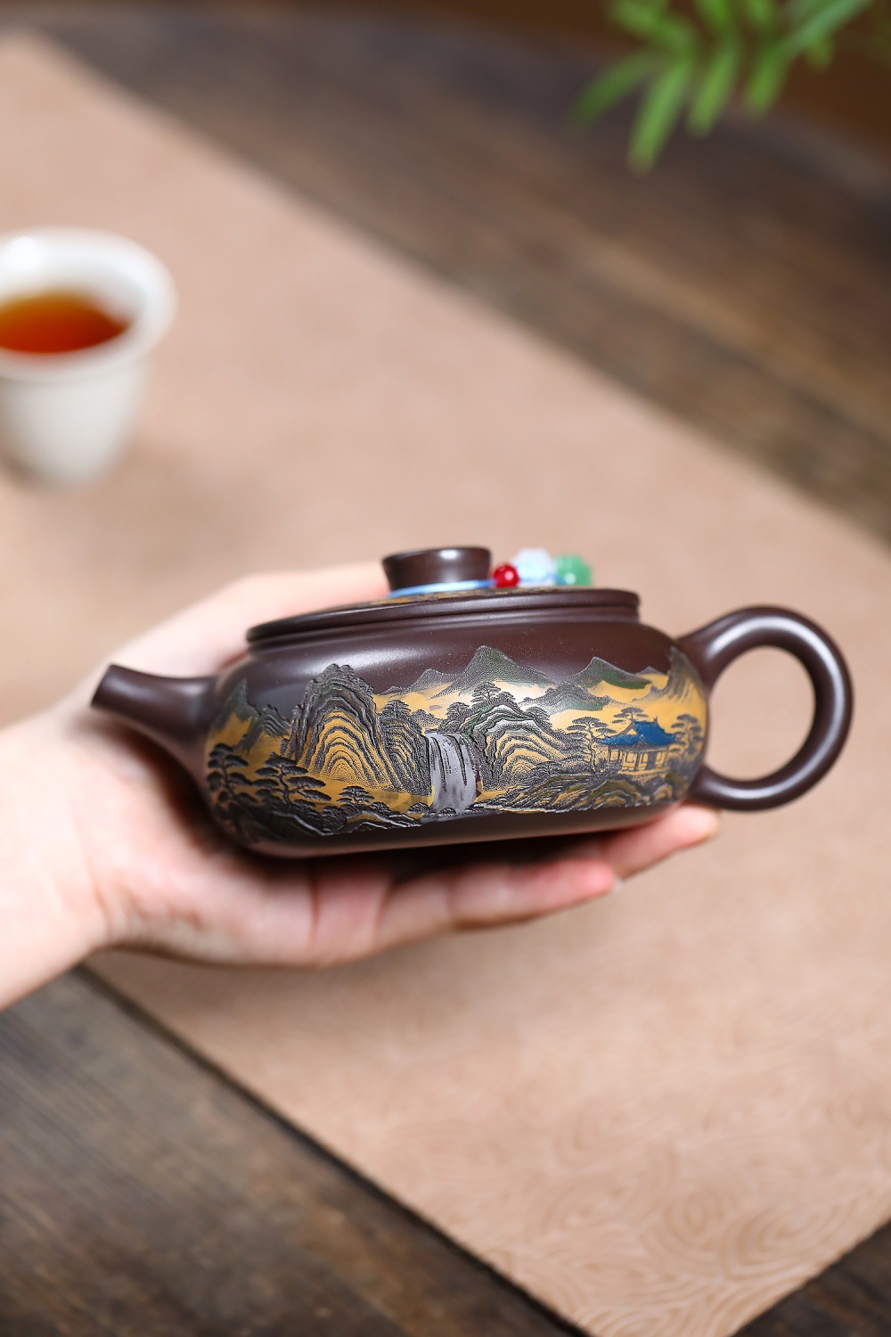 宜興紫砂壺原礦赤龍血漢瓦攬山壺(290ml),南山居精選紫砂壺,壺身雕刻山水瀑布樓閣圖案,泥繪點綴,展現精湛茶具工藝。