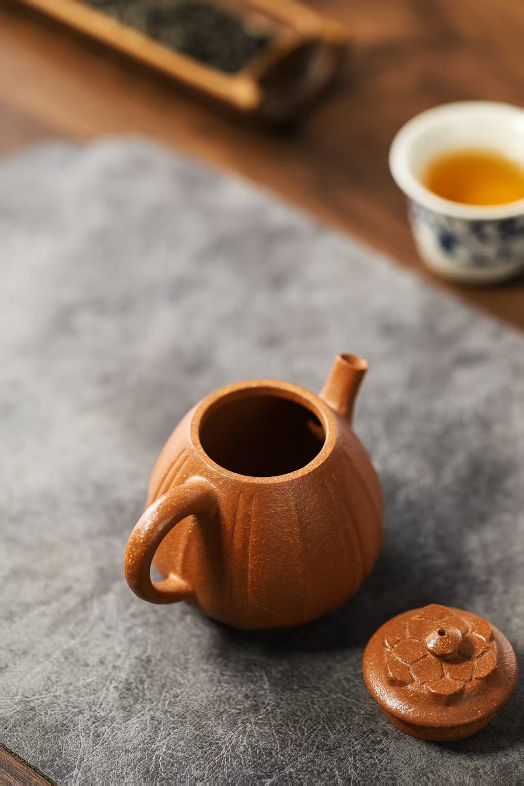 宜興紫砂壺原礦紫泥菱花潘壺(120ml)，南山居手工段泥筋紋壺，壺身線條流暢優雅，壺蓋雕刻精細蓮花造型，展現傳統紫砂工藝美學。