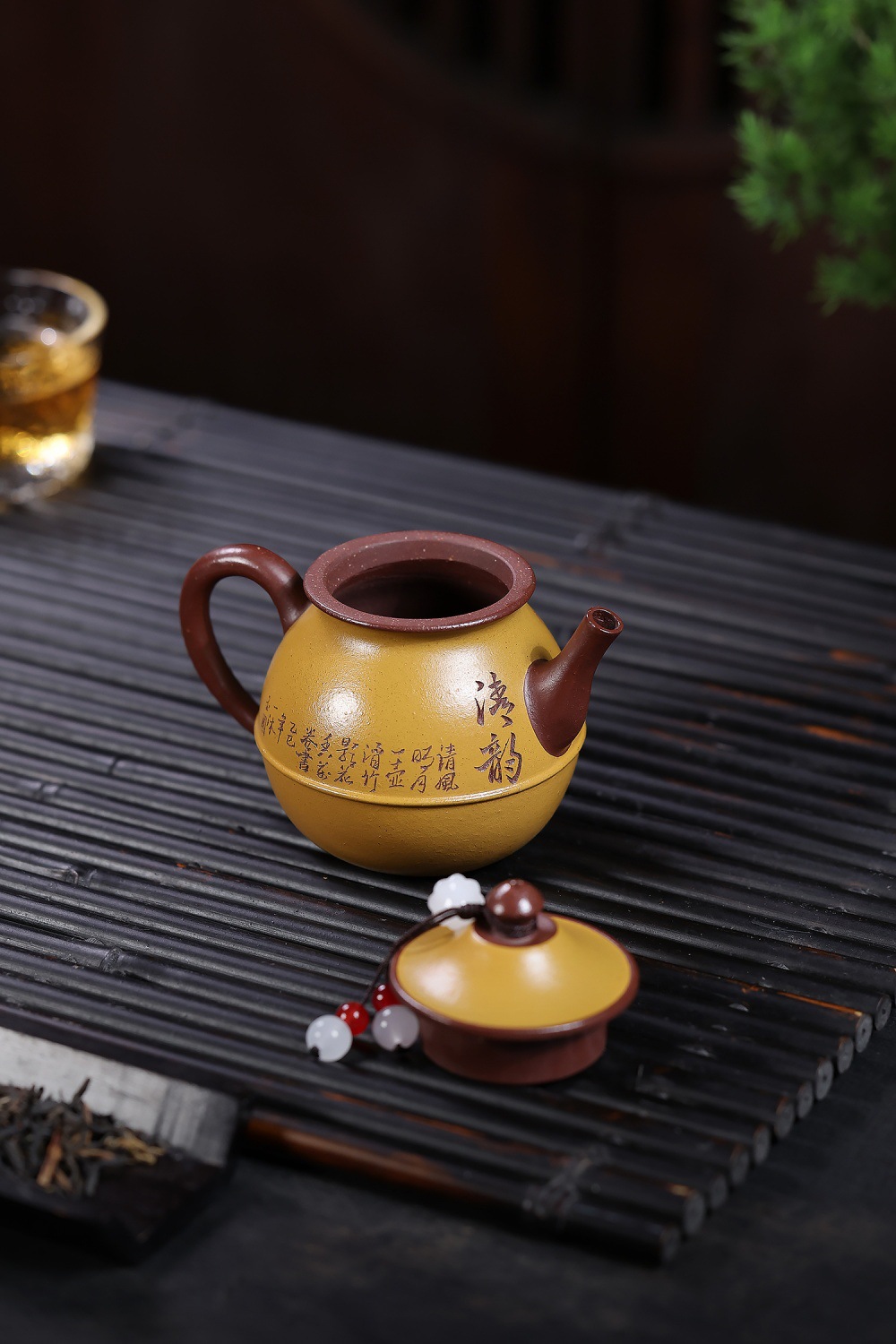 宜興紫砂壺原礦龍血砂雙色玉瓶壺(120ml)，南山居精緻雙色刻字圓壺，手工紫砂壺身呈黃褐色，搭配深褐色把手與壺嘴，展現獨特茶道美學。