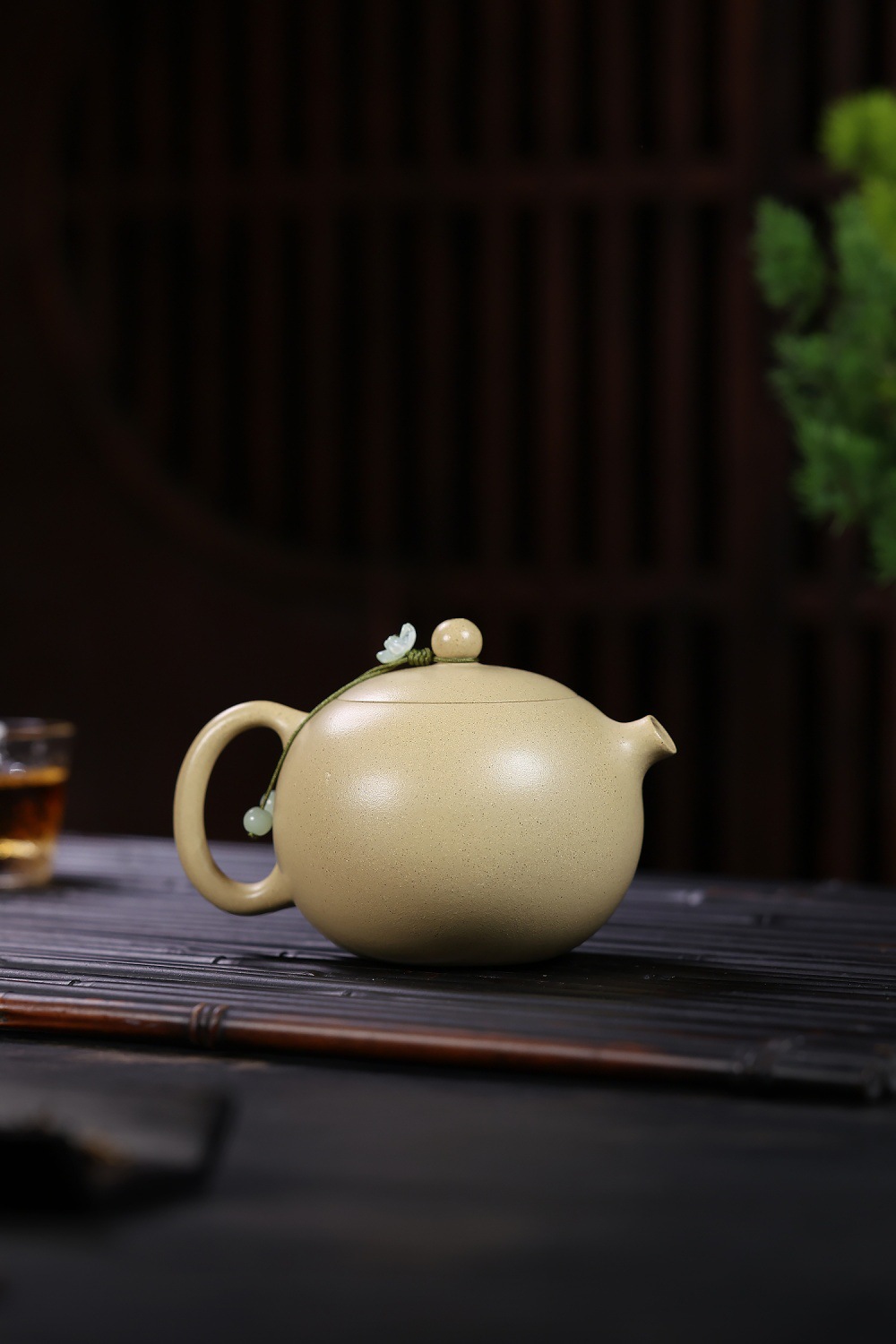 宜興紫砂壺原礦本山綠泥河豚西施壺(190ml)，南山居手工圓潤淺米色茶壺，壺蓋繫有雅緻花串與玉珠，置於竹茶席上，展現茶道靜雅。