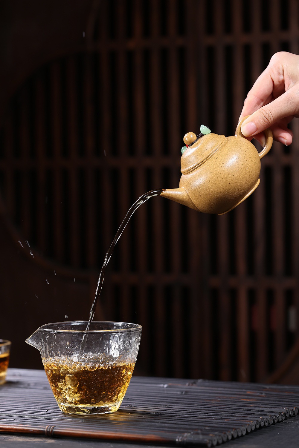 宜興紫砂壺原礦黃金段泥文人水平壺(180ml)，南山居手工朱泥壺傾注琥珀茶湯至錘紋玻璃公道杯，泥壺圓潤，茶流順暢。